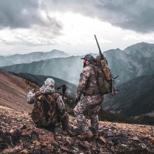 Two hunters glassing a mountainside, working through their pre-hunt checklist